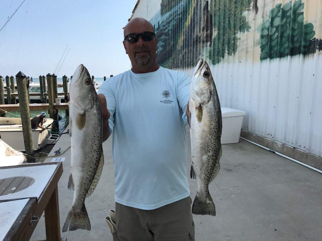 Man holding two speckled trout