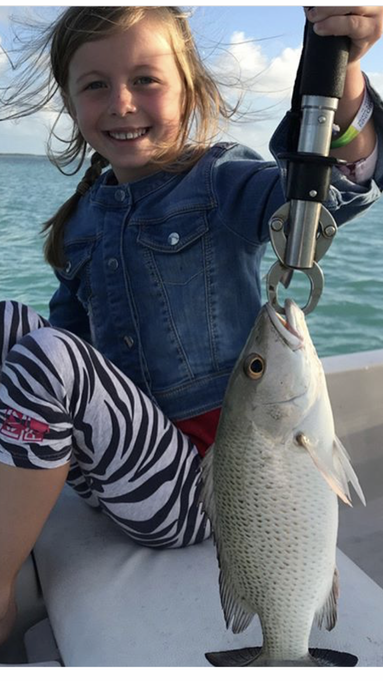Young lady holding mangrove snapper up