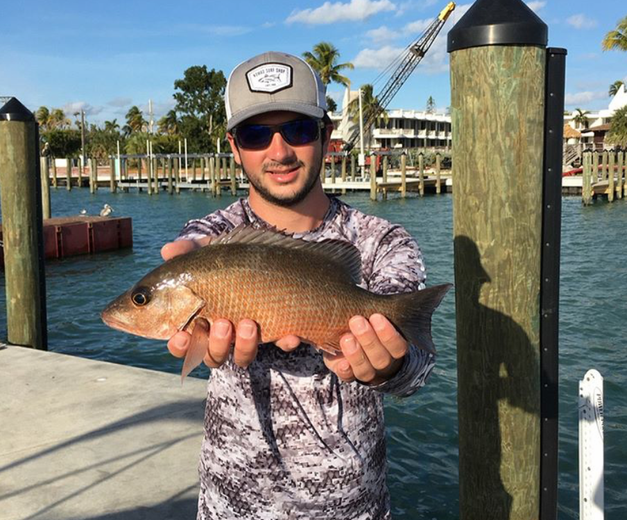 Man holding mangrove snapper in front with both hands