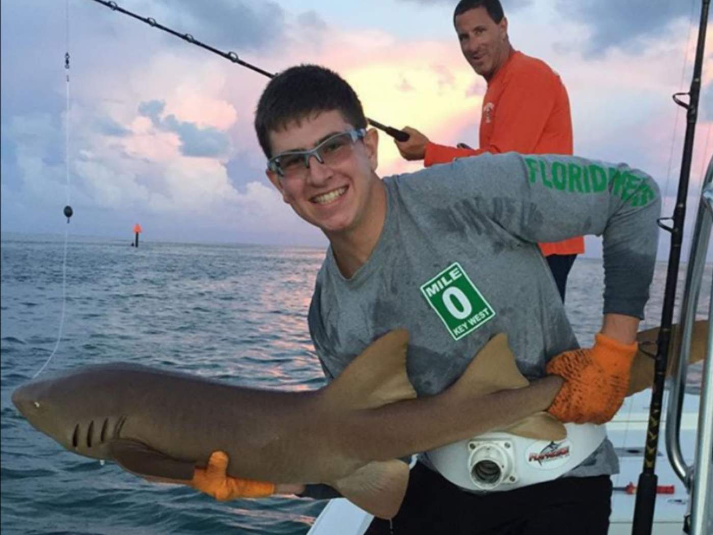 Man smiling holding freshly caught shark