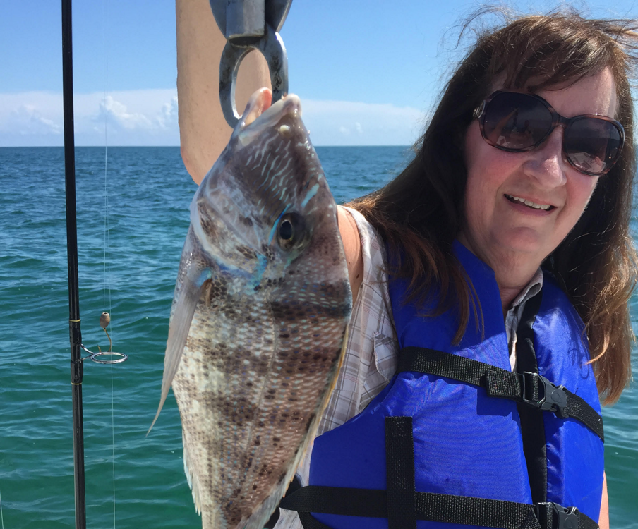 Woman holding up porgy fish